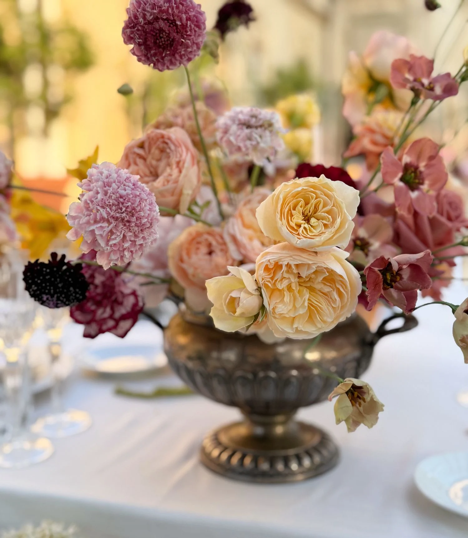 Romantic renaissance centerpiece with peach, orange english roses and pink scabiosa.