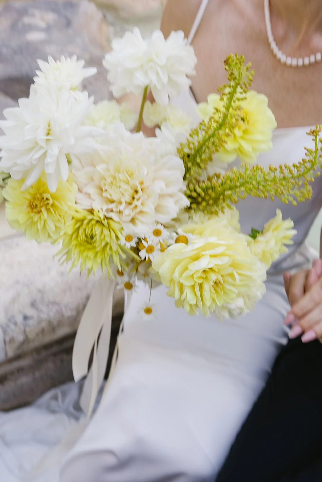 Yellow and cream dahlia arrangement resting on white linen